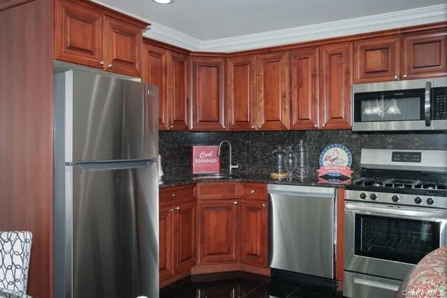 a kitchen with stainless steel appliances granite countertop a refrigerator and a stove top oven