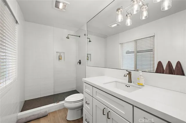 a bathroom with a sink a toilet and shower