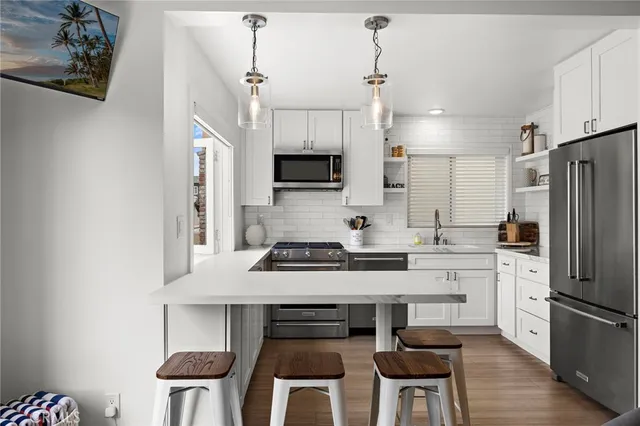 a kitchen with stainless steel appliances a stove a sink refrigerator and a cabinets