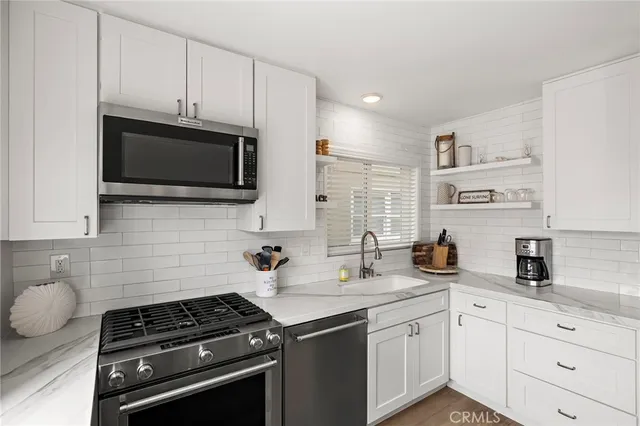 a kitchen with stainless steel appliances a sink stove and microwave