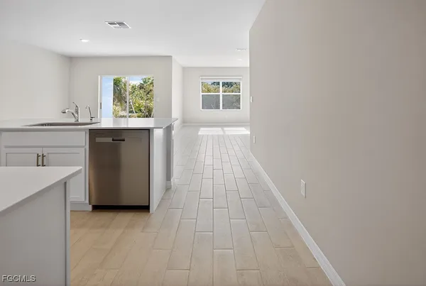 a view of kitchen with wooden floor electronic appliances and window