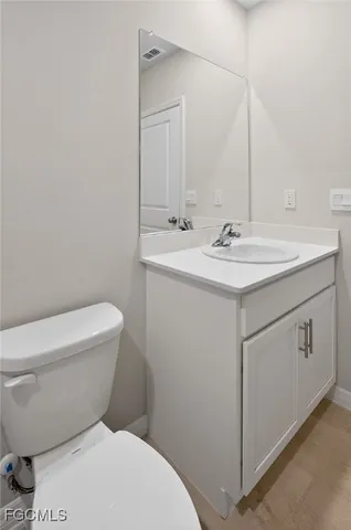a bathroom with a toilet a sink and mirror
