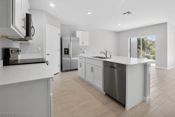 a kitchen with stainless steel appliances a sink stove and refrigerator