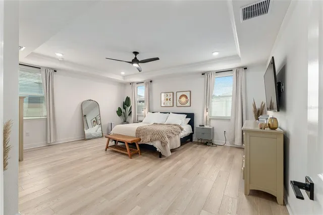 a spacious bedroom with a bed and a flat screen tv