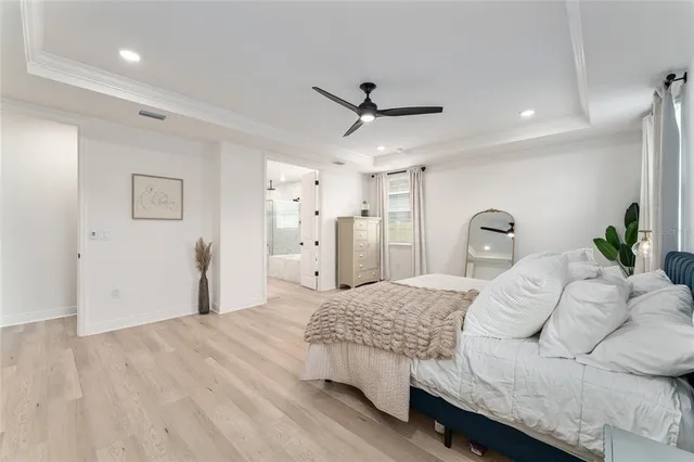 a bedroom with a large bed and a chandelier