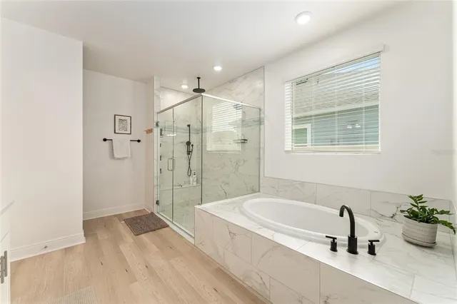 a bathroom with a tub sink and mirror