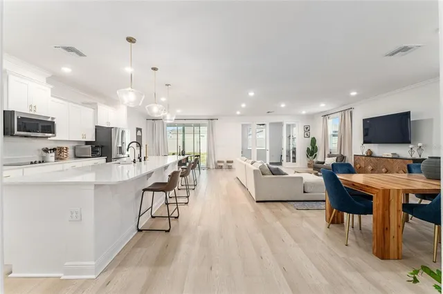 a living room with stainless steel appliances kitchen island granite countertop furniture and a flat screen tv