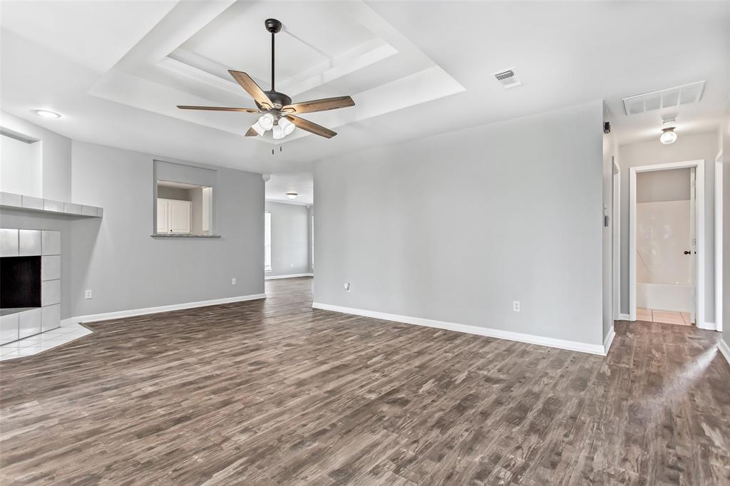 712 Billups Street Van Alstyne, TX 75495 - Photo 5 of 38 a view of an empty room with chandelier fan and a fireplace