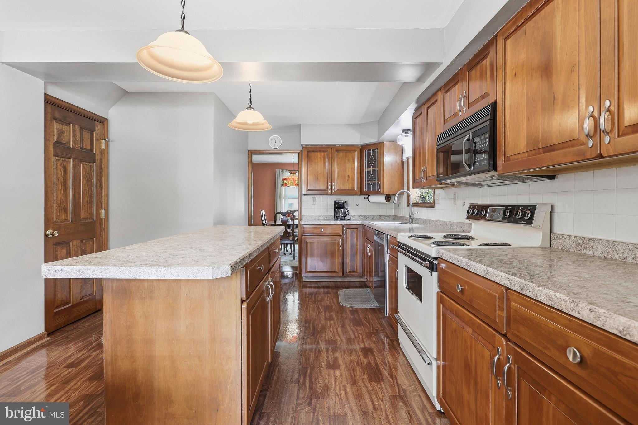527 Saxer Avenue Springfield, PA 19064 - Photo 10 of 33 a kitchen with stainless steel appliances granite countertop a sink a stove and a wooden floors