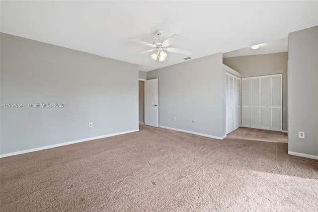 a view of an empty room with a ceiling fan