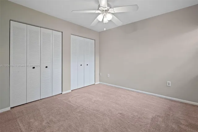 a view of an empty room and chandelier fan