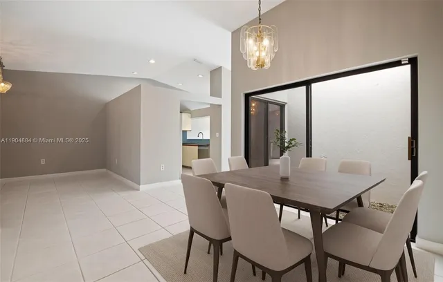 a view of a dining room with furniture and a chandelier