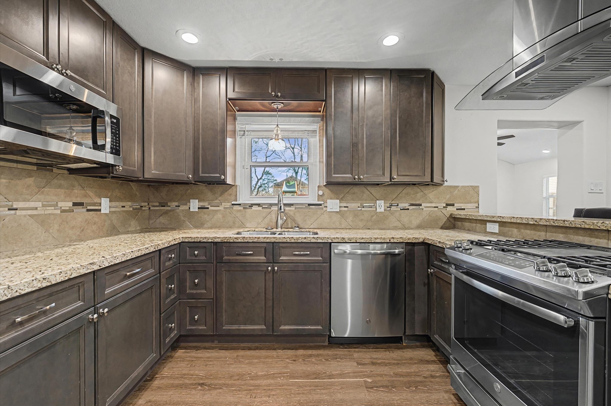 3812 Hardin Road Baytown, TX 77521 - Photo 4 of 30 The kitchen shines with beautiful granite countertops, a tiled backsplash, stainless steel appliances, and a breakfast bar perfect for casual mornings or easy entertaining.