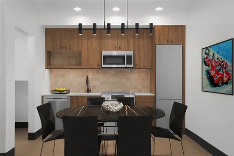 a kitchen with a dining table chairs and a refrigerator
