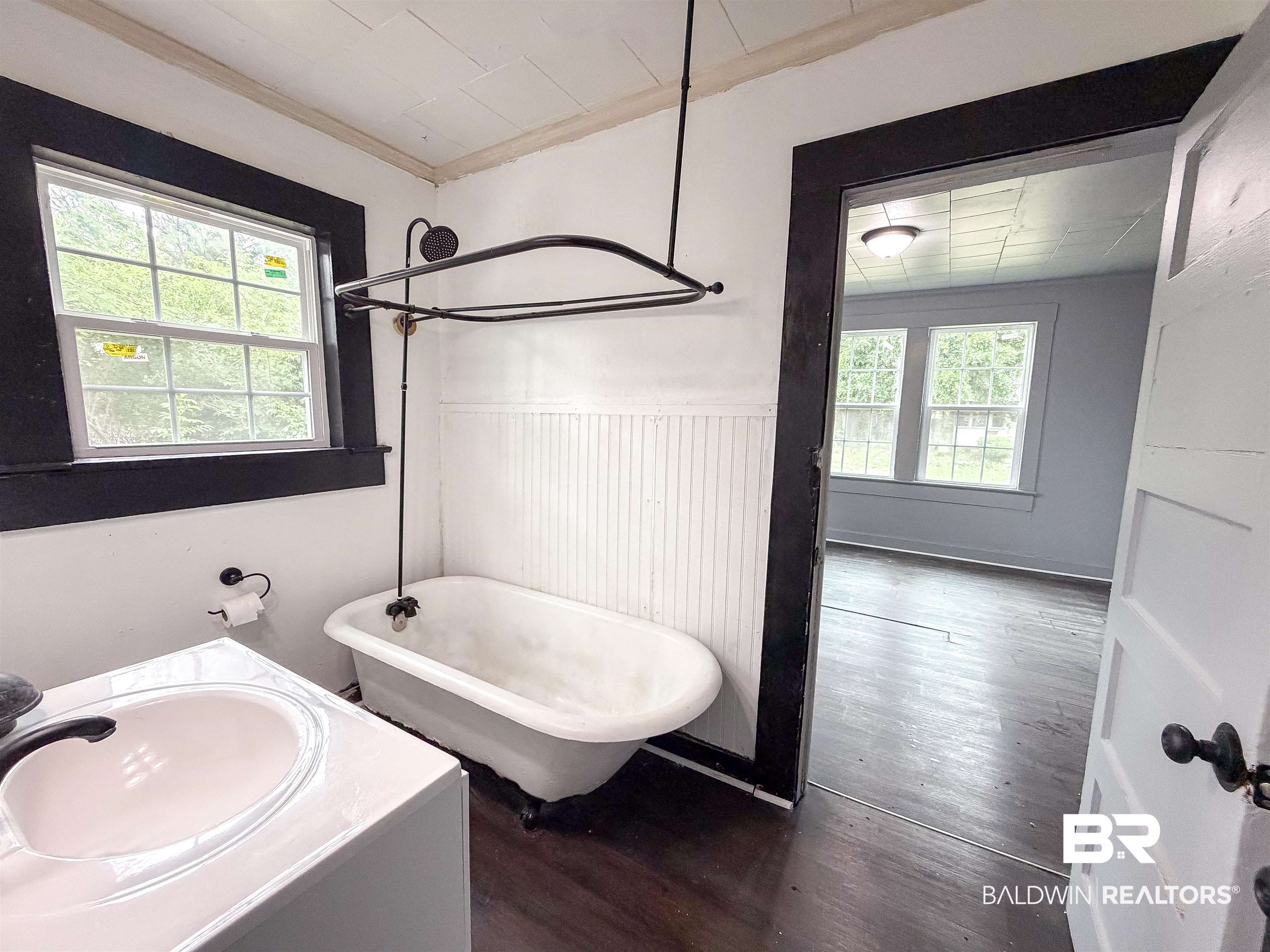 38 Flock Avenue Mobile, AL 36610 - Photo 15 of 27 Bathroom featuring a freestanding clawfoot tub with shower attachment, single vanity with integrated sink, beadboard wainscoting, and wood-finish flooring