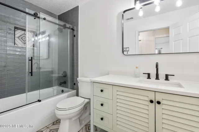 a view of an empty room with wooden floor and a ceiling fan