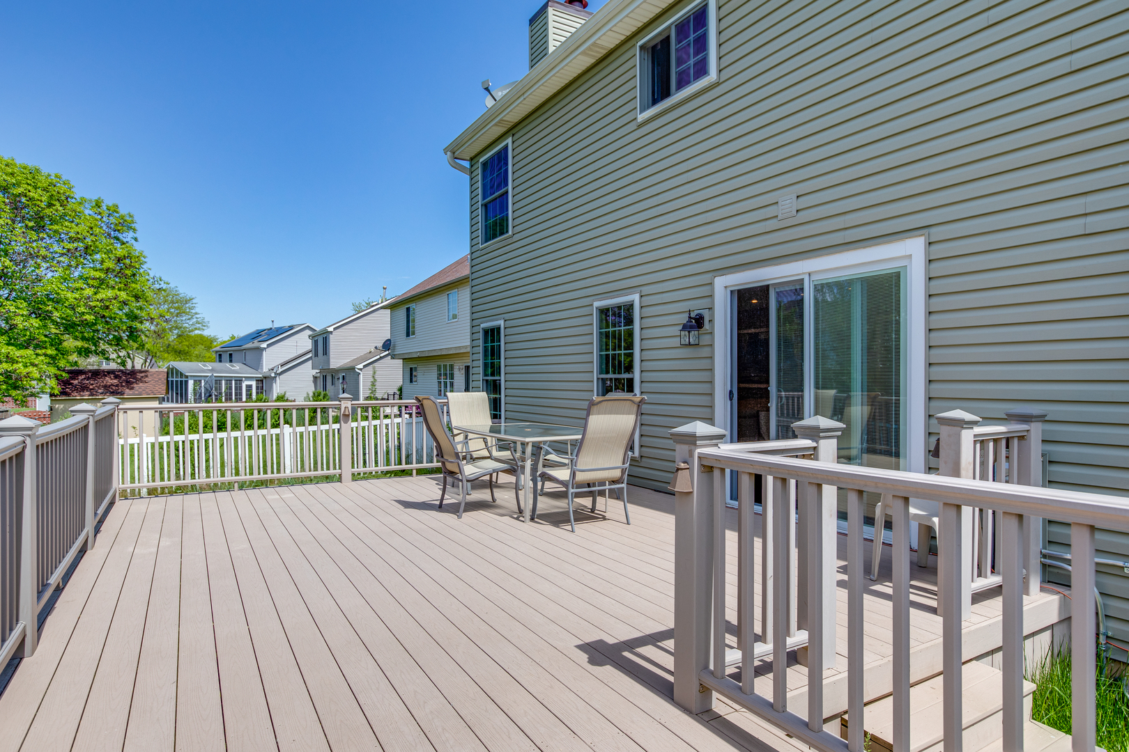 718 Huntington Drive Carol Stream, IL 60188 - Photo 26 of 28 a view of a roof deck with table and chairs and wooden floor