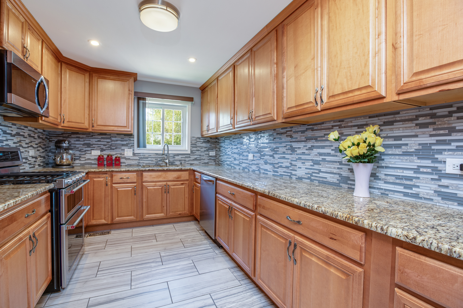 718 Huntington Drive Carol Stream, IL 60188 - Photo 7 of 28 a kitchen with stainless steel appliances granite countertop a sink a stove cabinets and a counter top space