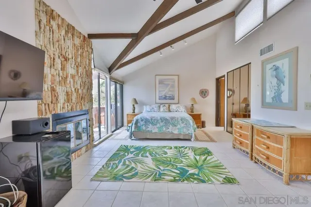 a spacious bedroom with a large bed and a chandelier