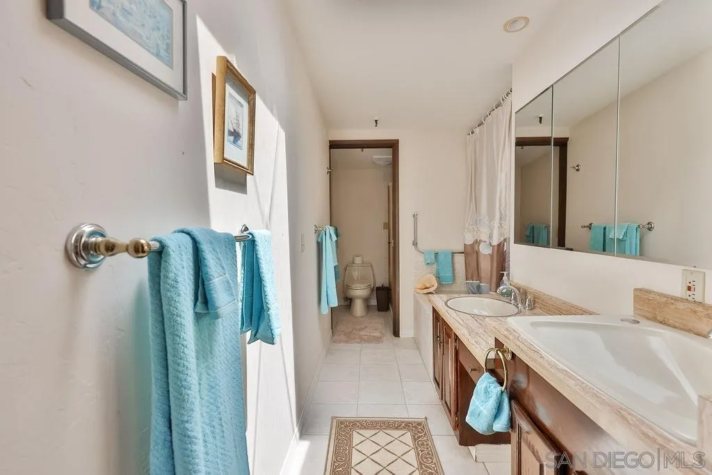 835 D Avenue, Unit 4 Coronado, CA 92118 - Photo 28 of 35 a bathroom with a tub sink and mirror