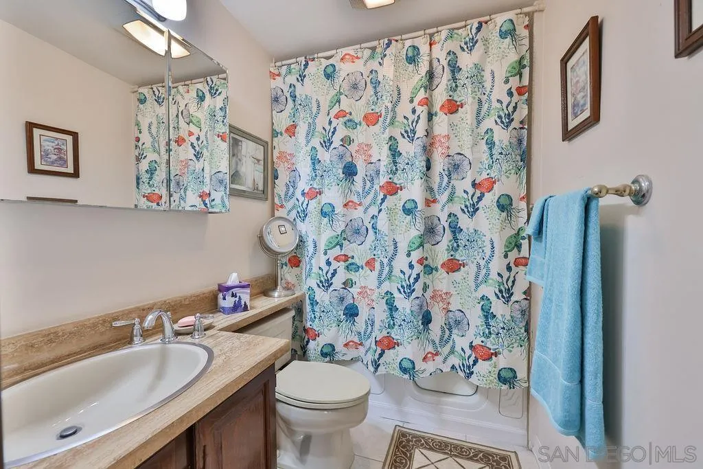835 D Avenue, Unit 4 Coronado, CA 92118 - Photo 30 of 35 a bathroom with a sink toilet and shower curtain
