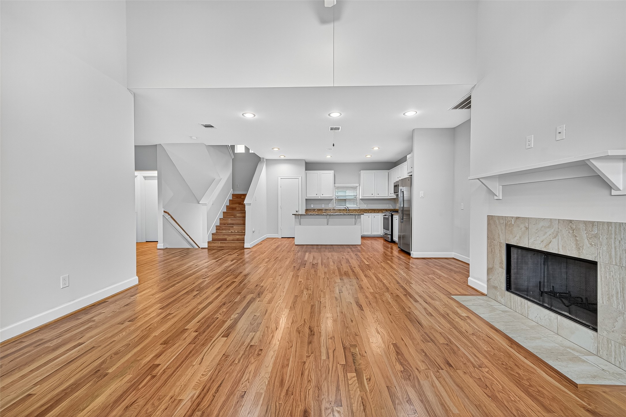 11510 Main Ash Drive Houston, TX 77025 - Photo 13 of 39 a open kitchen with white cabinets wooden floor and stainless steel appliances