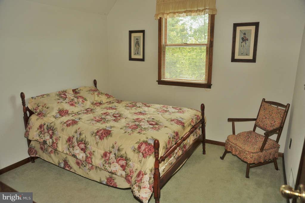 6005 Hynson Road Rock Hall, MD 21661 - Photo 14 of 22 a bedroom with a bed and chair