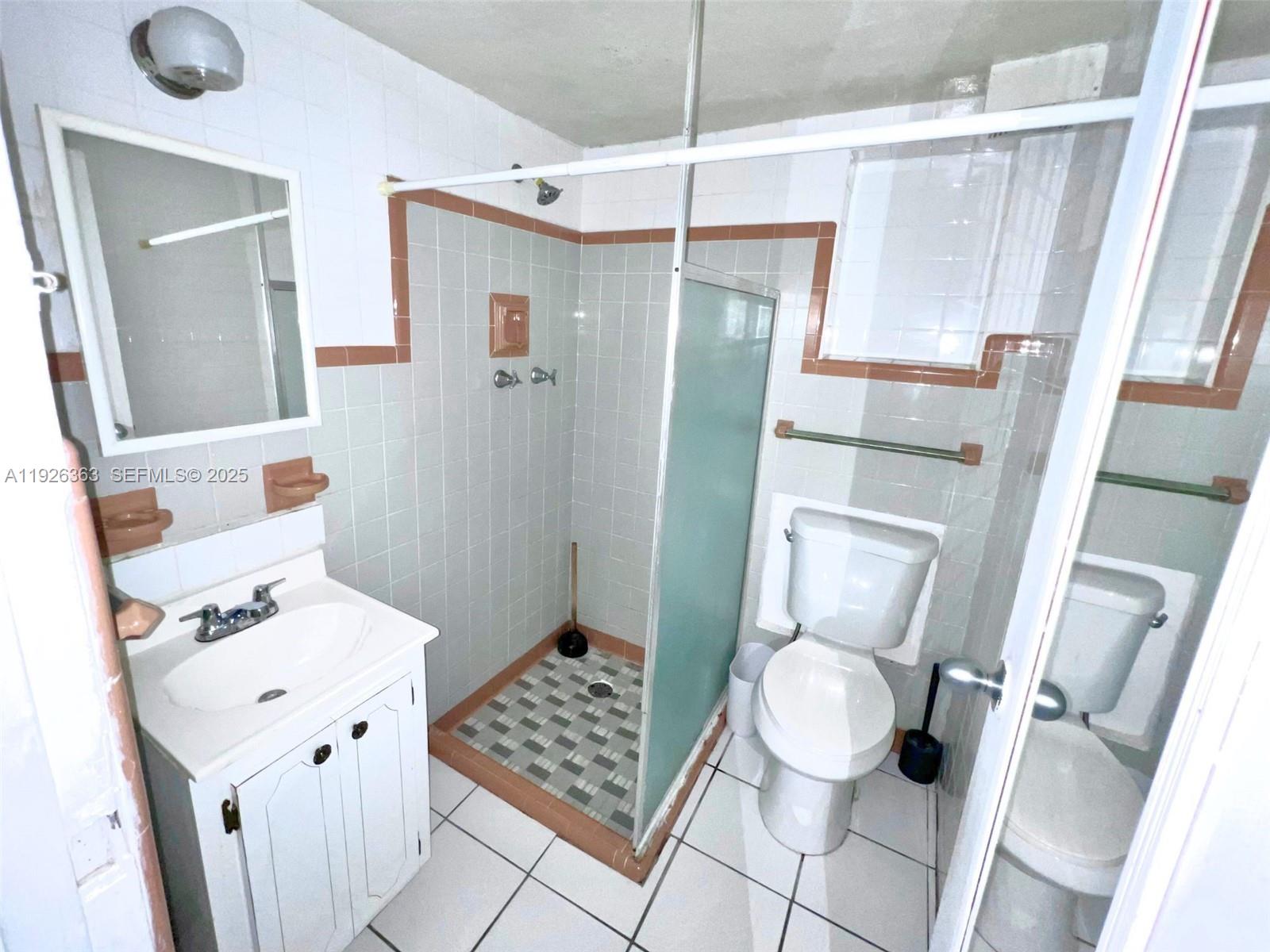 227 Phoenetia Avenue, Unit 3 Coral Gables, FL 33134 - Photo 4 of 10 a bathroom with a sink toilet and shower