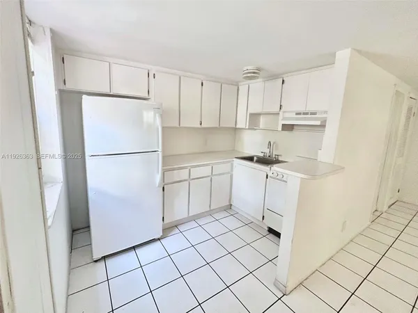 a kitchen with white cabinets and white appliances