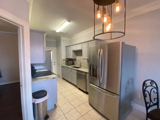 a kitchen with stainless steel appliances granite countertop a refrigerator and a stove