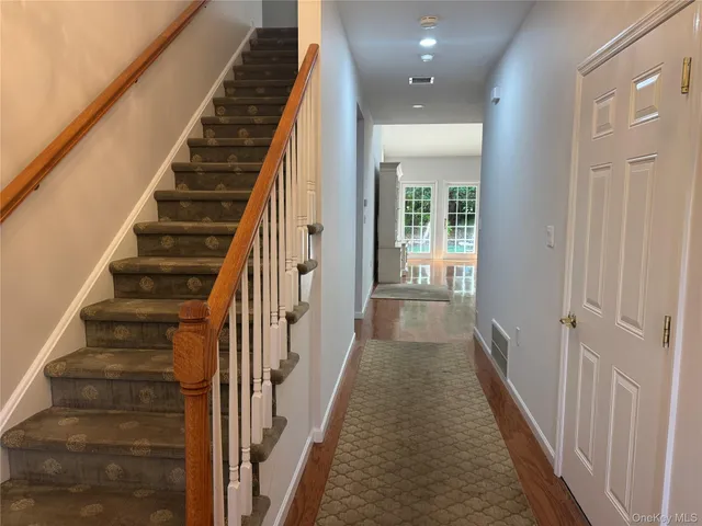 a view of a hallway with wooden floor and entryway