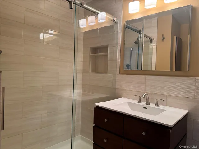 a bathroom with a sink mirror and shower