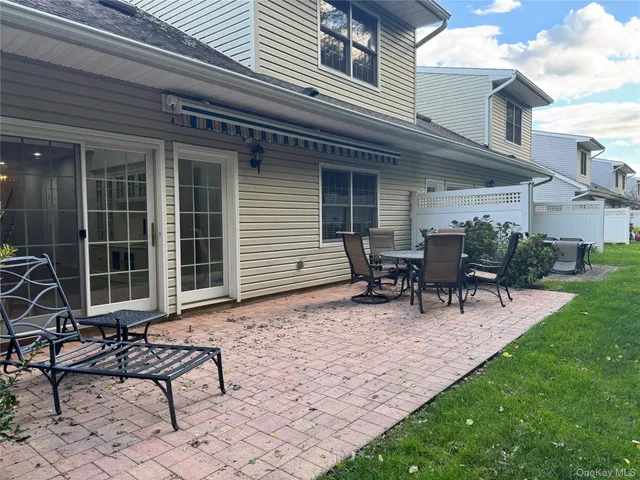 a view of a house with backyard and sitting area