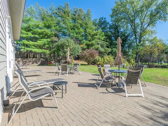 a view of a chairs and table in patio with a yard