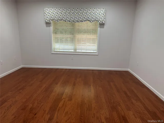 a view of a room with wooden floor and a window