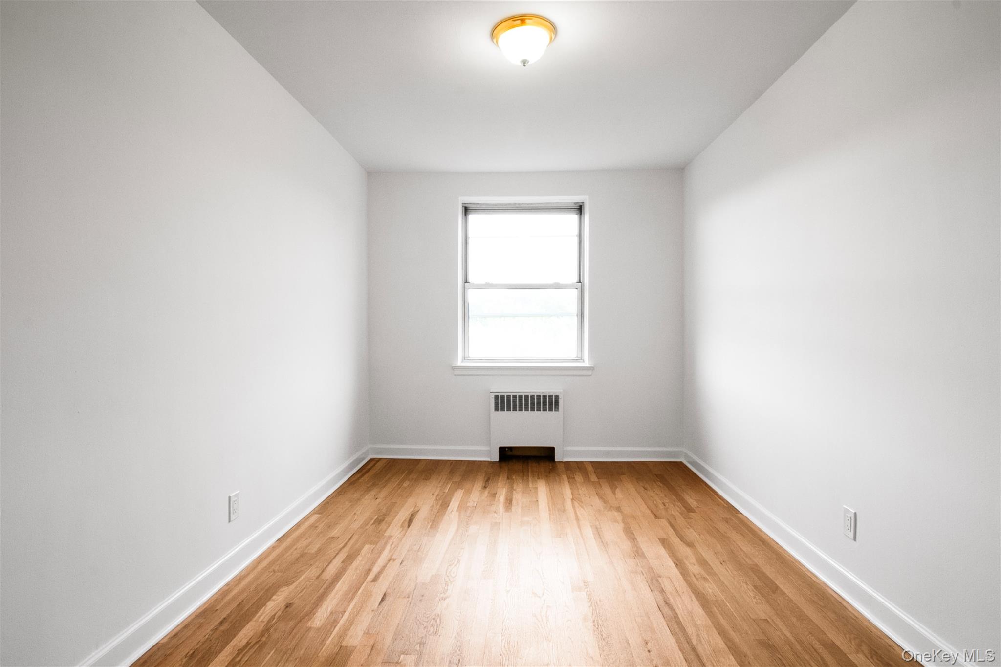 485 Bronx River Road, Unit A50 Yonkers, NY 10704 - Photo 13 of 23 an empty room with wooden floor and windows