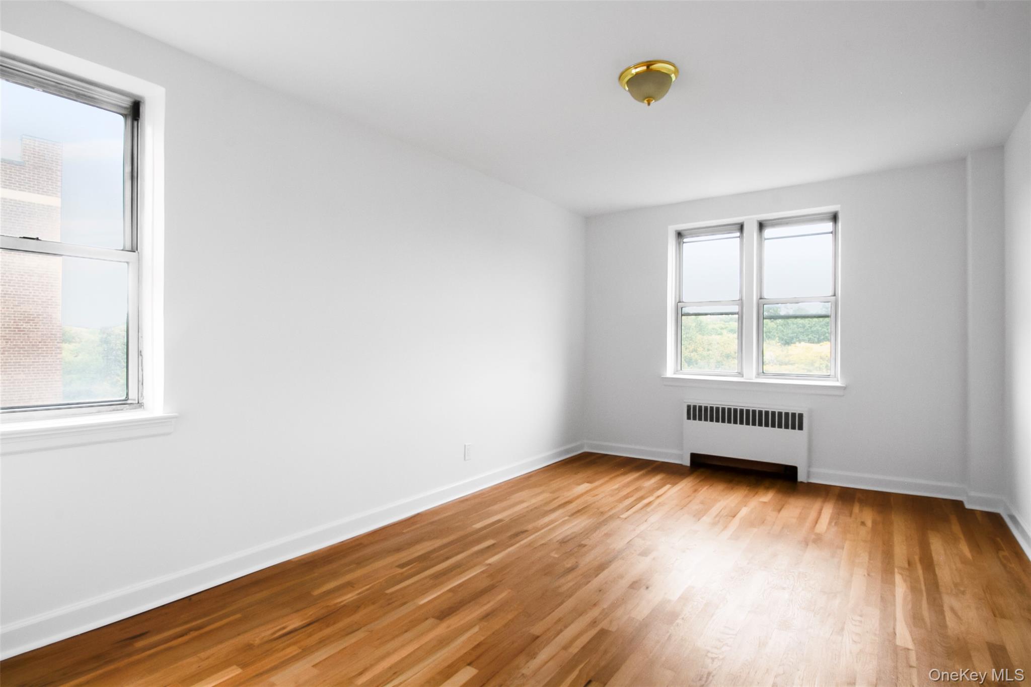 485 Bronx River Road, Unit A50 Yonkers, NY 10704 - Photo 17 of 23 an empty room with wooden floor and windows