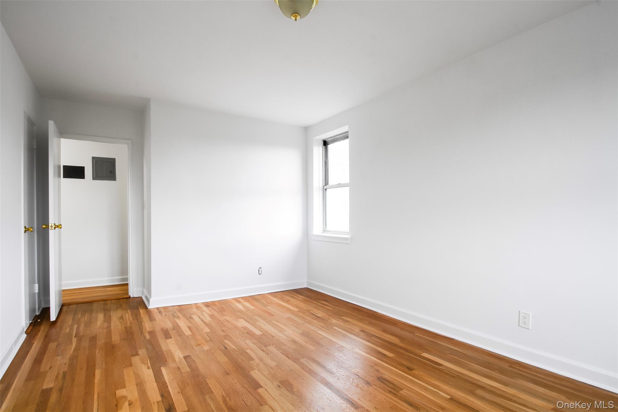 485 Bronx River Road, Unit A50 Yonkers, NY 10704 - Photo 19 of 23 an empty room with wooden floor and windows