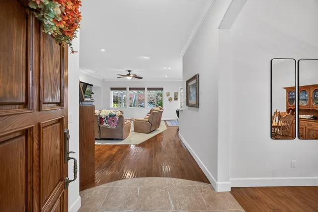 a dining room with wooden floor a chandelier a wooden table and chairs