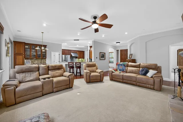 a kitchen with stainless steel appliances granite countertop a table chairs stove and refrigerator