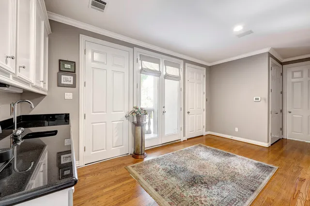 a view of a livingroom with wooden floor and kitchen space