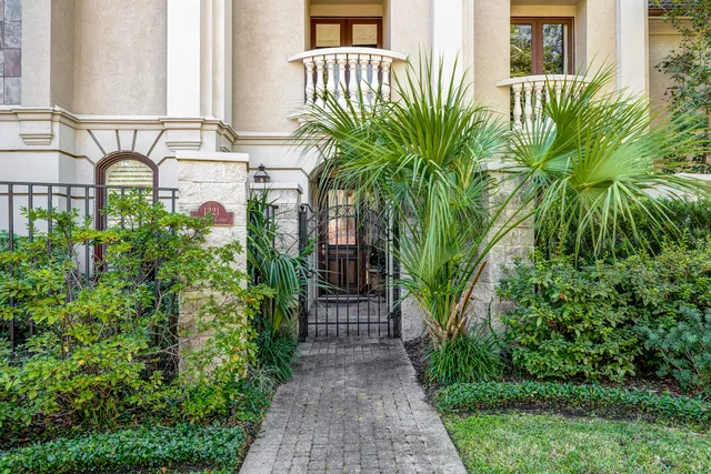 a front view of a house with a yard and potted plants