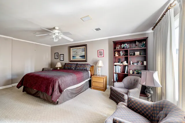 a spacious bedroom with a bed a couch and a bookshelf
