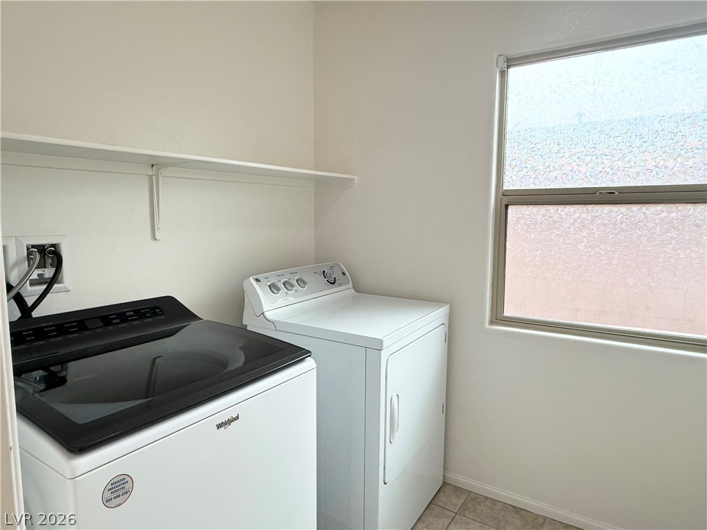 8231 Buffalo Ranch Avenue Las Vegas, NV 89147 - Photo 19 of 22 Functional laundry space featuring modern appliances and a privacy window.