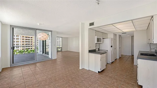 a view of a kitchen with a sink and dishwasher a stove top oven with wooden floor