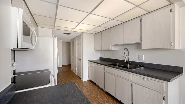 a kitchen with granite countertop a sink and a refrigerator