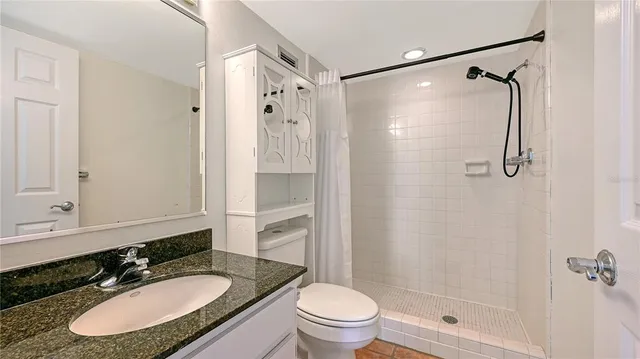 a bathroom with a sink toilet double vanity and shower