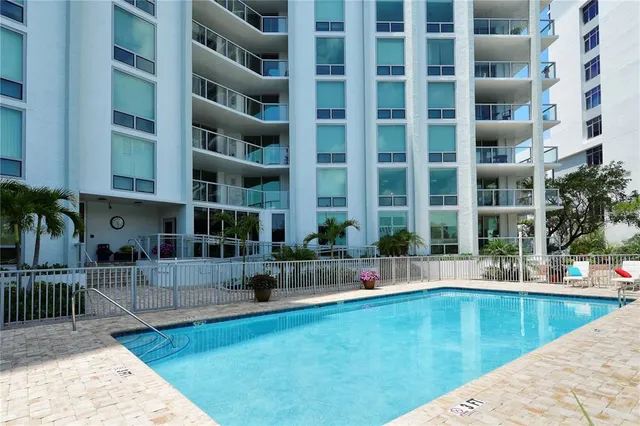 a view of a patio with a table and chairs under an umbrella with potted plants