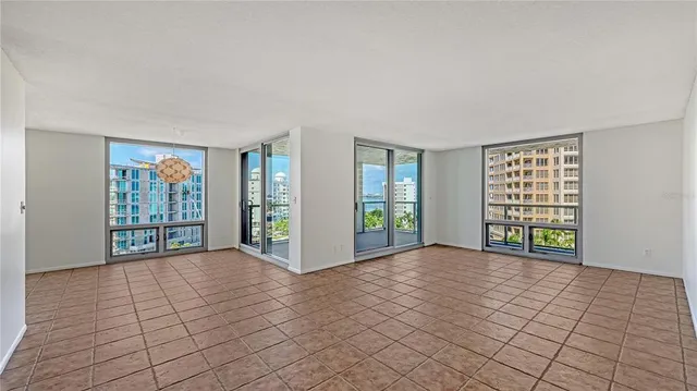 a view of an empty room with window and a kitchen area