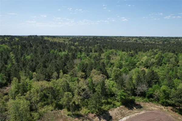 an aerial view of a houses with a yard and lake view